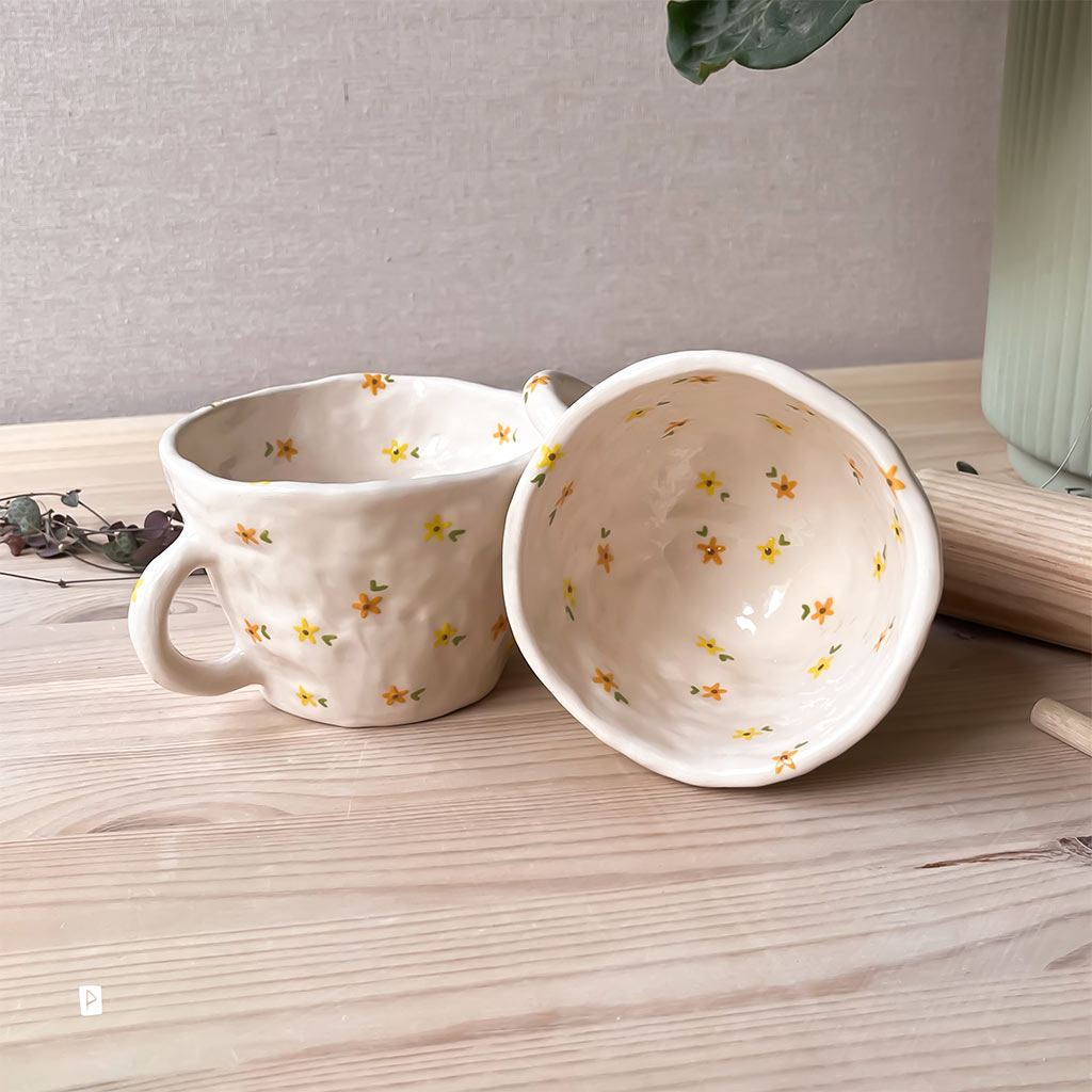 Taza de cerámica artesanal con flores amarillas y naranjas