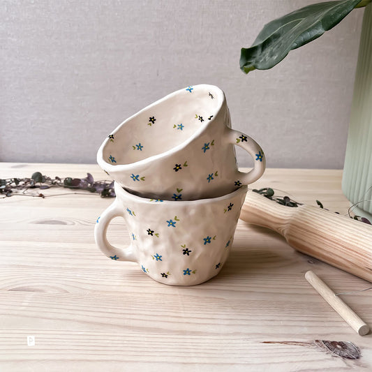 Taza de cerámica artesanal con flores azules y negras