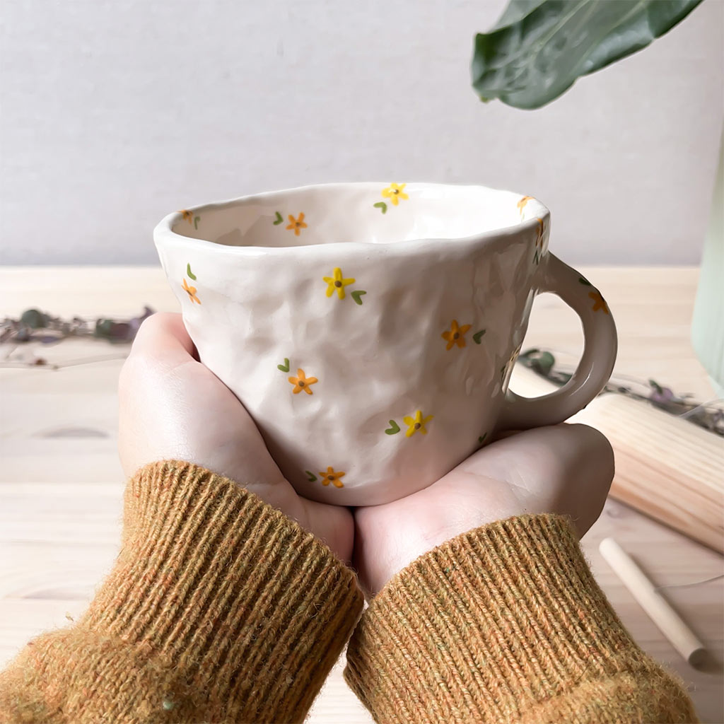 Taza de cerámica artesanal con flores amarillas y naranjas