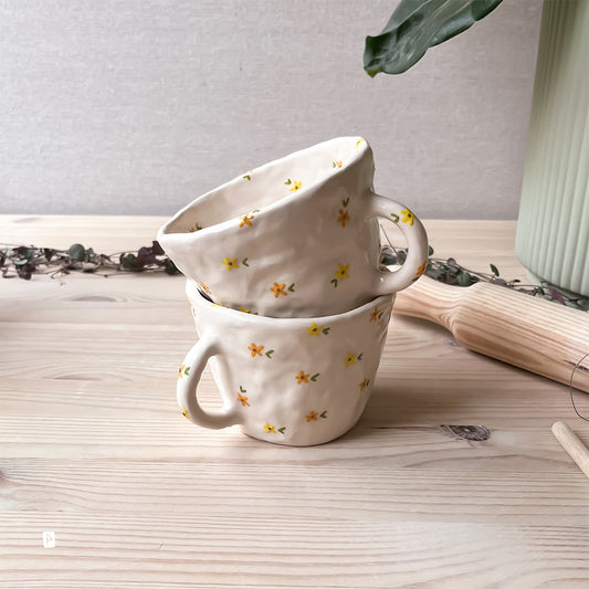 Taza de cerámica artesanal con flores amarillas y naranjas