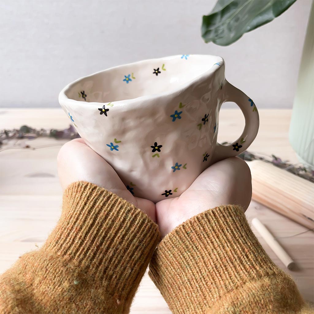 Taza de cerámica artesanal con flores azules y negras