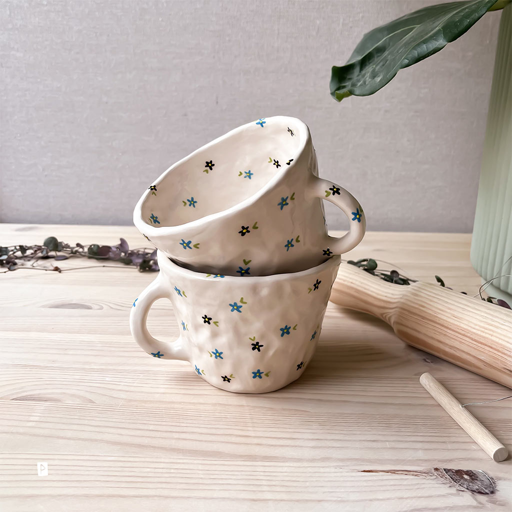 Taza de cerámica artesanal con flores azules y negras